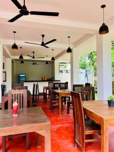a dining room with wooden tables and chairs at ANB Surf View in Tangalle