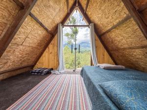 a bedroom with a bed and a large window at Chalé Agulhas Negras in Resende
