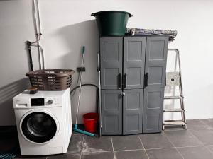 a washing machine next to a cabinet with a bucket on it at Maeva I Papara in Papara