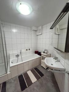 a white bathroom with a tub and a sink at Vintage Traum in Hückelhoven