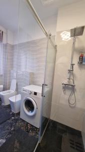 a bathroom with a washing machine and a toilet at Appartamento Orchidea in Monfalcone +13 photos