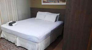 a bed in a hotel room with a phone on it at STOP Mar Suite Privada - NI in Nova Iguaçu