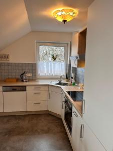 a kitchen with white cabinets and a sink and a window at Vintage Traum in Hückelhoven +16 photos