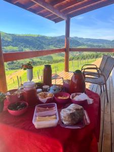 a table with food on a red table cloth at Oasis na montanha in Bueno Brandão