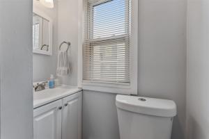 a white bathroom with a toilet and a sink at 404 W Maple Ave, Unit A in Wildwood +11 photos