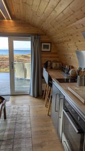 a kitchen with a counter with a view of the ocean at Herons Rest Pod By The Sea in Morar Station