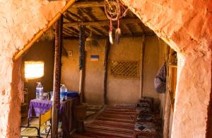 ein Raum mit einem Tisch mit einer lila Tischdecke in der Unterkunft Sahara Peace camp in Zagora