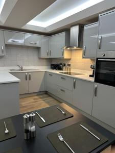 a kitchen with white cabinets and a black counter top at Riverview Apartment 2 in Matlock