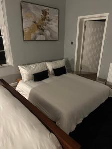 a bedroom with a large white bed with two pillows at Riverview Apartment 2 in Matlock