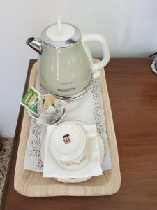 a tray with a tea pot and a plate on it at DUETERRE Room & Host in Amelia