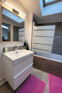 a bathroom with a sink and a mirror and a tub at L'Atelier Saint Michel in Bordeaux