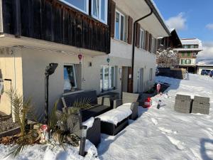 a house with snow on the ground in the yard at Studio with lake and mountain view in Spiez