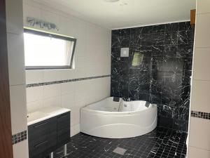 a black and white bathroom with a tub and a sink at Коттедж in Lappeenranta