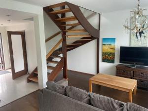 a living room with a couch and a wooden staircase at Коттедж in Lappeenranta