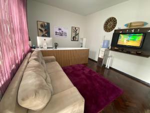 a living room with a couch and a tv at Açaizeiro Hostel in Belém