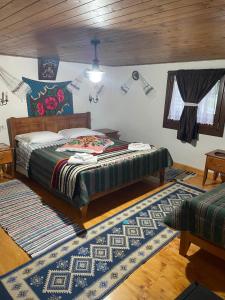 a bedroom with a bed and a rug at Căsuța Floarea Reginei in Borşa +13 photos