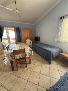 a bedroom with two beds and a table and chairs at A Casa do Amor in Vila do Porto