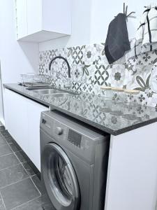 a kitchen with a washing machine under a counter at Canopy stay 4 in Sandton
