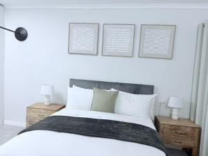 a bedroom with a white bed with two night stands and two lamps at Canopy stay 4 in Sandton