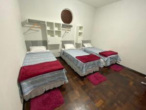 two beds in a room with wooden floors at Açaizeiro Hostel in Belém