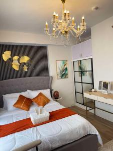 a bedroom with a large bed with a chandelier at Ona's Condo in Bacolod +15 photos