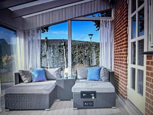 a patio with two wicker chairs and a window at Grønningen Retreat in Billund