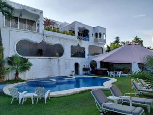 a house with a swimming pool in the yard at Hotel Marina Palace Tequesquitengo in Tequesquitengo