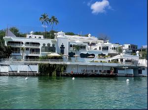 a large white building next to a body of water at Hotel Marina Palace Tequesquitengo in Tequesquitengo