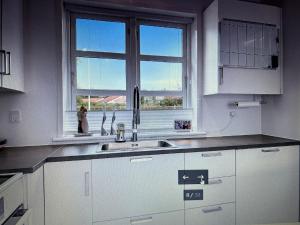a white kitchen with a sink and a window at Grønningen Retreat in Billund +13 photos