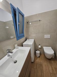 a bathroom with a sink and a toilet and a mirror at Aspalathos I & ΙΙ in Kamárion +16 photos