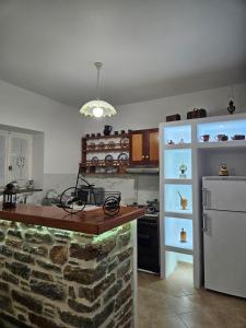 a kitchen with a stone counter and a refrigerator at Aspalathos I & ΙΙ in Kamárion