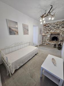a bedroom with a bed and a stone fireplace at Aspalathos I & ΙΙ in Kamárion