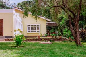 a house with a tree in the yard at Avana Home in Arusha