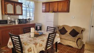 a living room with a table and a couch at Pacific View Apartment in Roseau