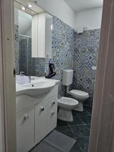a bathroom with a sink and a toilet and a mirror at Casa Vacanze AFEA Torre dell'Orso Salento Puglia in Torre dell'Orso