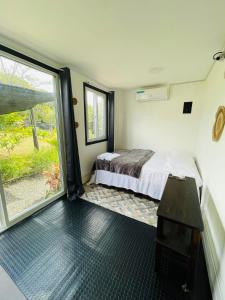 a bedroom with a bed and a large window at CASA HARPIA Apartamentos Studio in Pedasí Town