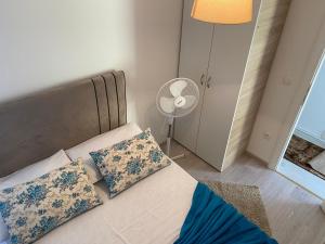 a bedroom with a bed with two pillows and a fan at Apartments Villa ALEN in Mimice