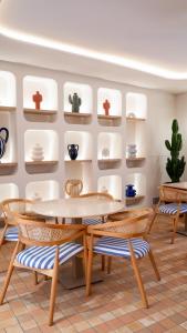 a dining room with a table and chairs and shelves at Hôtel Gabriel in Menton
