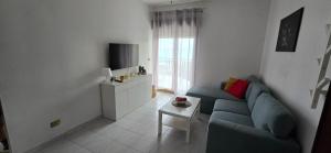 a living room with a blue couch and a tv at Maremonti in Letojanni +23 photos
