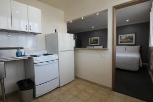 a kitchen with a stove and a refrigerator and a bed at Dunes Inn - Wilshire in Los Angeles