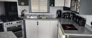 a kitchen with white cabinets and a sink and a stove at Trecco Bay Private rentals in Newton +5 photos