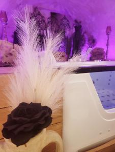 a white feather hat sitting next to a white phone at L'Atelier Des Roses, Lunéville centre in Lunéville