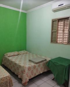 a bedroom with two beds and a green wall at Imperial Hotel in Santo Antônio do Descoberto