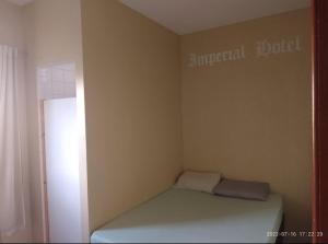 a small room with a bed in the corner at Imperial Hotel in Santo Antônio do Descoberto
