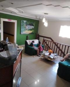two children sitting on a couch in a living room at Imperial Hotel in Santo Antônio do Descoberto