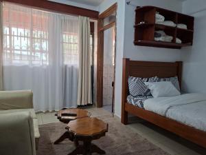 a bedroom with a bed and a coffee table at MJ Homes Eldoret Studio in Eldoret