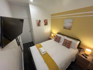 a hotel room with a bed and a flat screen tv at Minstead Houses - 5 Bedroom Contractor House Sleeps 9 Parking for 2 Vans Near Bromford Duddeston Fort Dunlop Star City HS2 in Birmingham