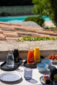 a table with glasses and plates of food on it at Mas Oréa côté piscine in Gordes