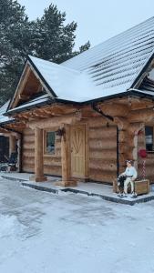 a log cabin with snow on the roof at Ośrodek u Polaka-domek góralski in Radkowice +48 photos