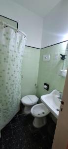 a bathroom with a toilet and a sink at Necochea Real Hotel in Necochea
